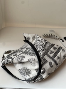 Close-up of black and white paisley print tote bag with durable black leather strap