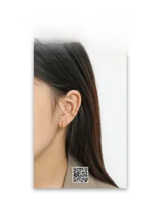 Detail of elegant gold hoop earrings and ear cuffs set on model ear in French vintage style