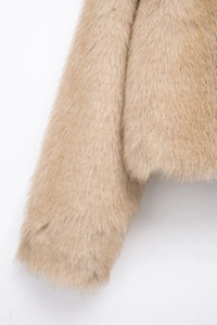 Detailed macro view showing the dense texture and soft fibers of the camel faux fur coat