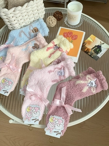 Detail of soft coral fleece socks with cute cartoon embroidery and ribbon packaging
