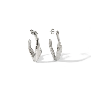 Macro shot of silver irregular geometric hoop earrings with molten hammered texture