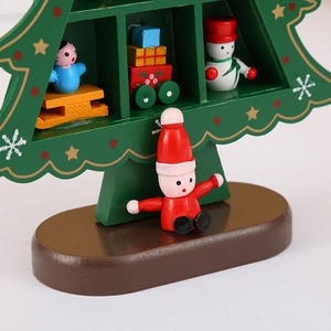 Macro shot of green wooden Christmas tree with Santa, snowman and gift box miniatures