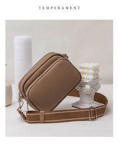 Detail view of khaki brown lychee grain leather crossbody bag with dual zipper compartments
