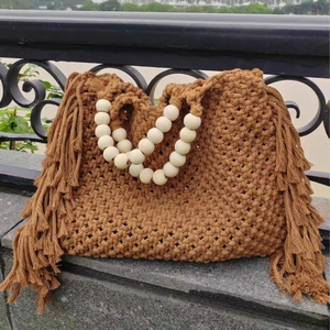 Brown macrame woven tote bag with large wooden bead handles and long fringe details