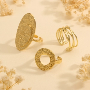 Detailed view of three gold hammered rings set featuring textured hollow line designs