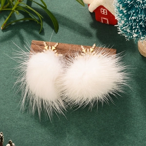 Golden reindeer zircon earrings with white fur balls on green velvet festive background
