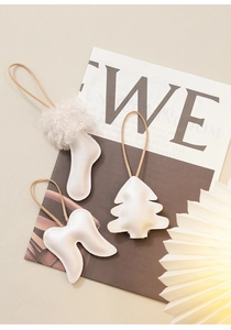 White leather Christmas tree and sock ornaments with fur detail on artistic magazine base