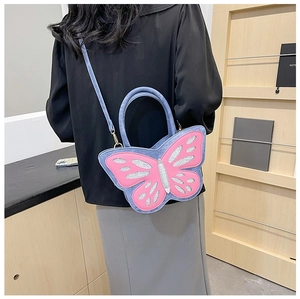 Detail of butterfly-shaped crossbody bag with pink sequins and metallic hooks on a model