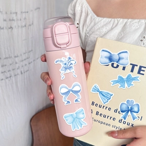Detail of cute blue bow stickers on a pink insulated water bottle held by a model