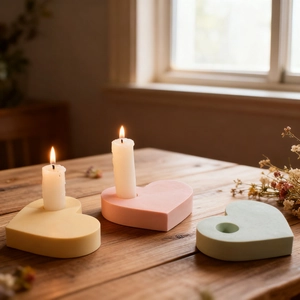 Set aus herzförmigen Kerzenhaltern in Macaron-Farben auf einem Holztisch Dekoration