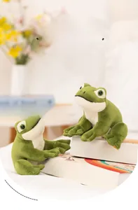 Two realistic green plush frogs in sitting pose on decorative books with home decor