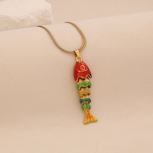 Close-up of a flexible colorful enamel fish pendant on a golden snake chain necklace