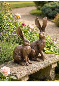Detalle de dos estatuas de conejo en resina de bronce vintage para jardín y hogar