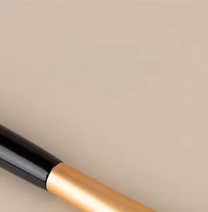 Detailed macro view of the gold thickened aluminum tube and black handle of a makeup brush