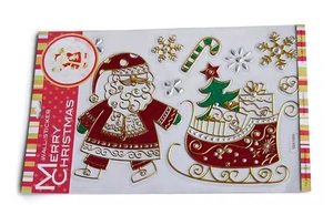 Flat lay of Christmas wall stickers featuring Santa Claus and golden glitter snowflakes