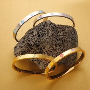 Polished stainless steel bracelets with colorful enamel plum flowers on volcanic rock