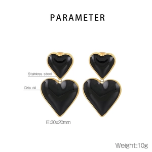 Vue détaillée des boucles d'oreilles cœur avec émail noir et dimensions de 30x20 mm