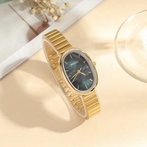 Detail view of oval gold watch with green marble dial and matching link bracelet