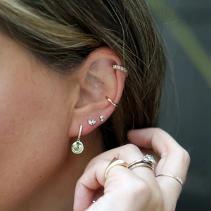 Close-up of minimalist sterling silver cluster stud earrings on a model ear lobe