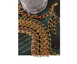 Close-up of gold Cuban chain necklace and earrings with colorful zircon gemstones