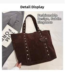 Detail shot of brown suede tote bag featuring silver studs and heart-shaped pendant