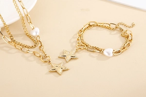 Detail of gold double-layer necklace set with white heart and star pendants