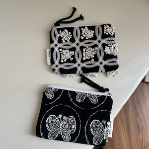 Mini black canvas coin purses with white floral embroidery and zipper closure