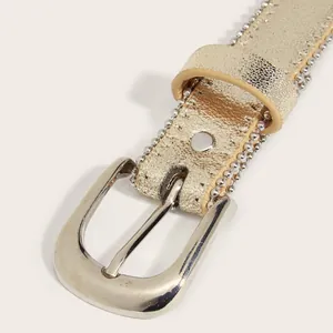Detail of golden leather kids belt with silver bead trim and polished horseshoe buckle