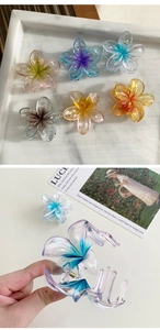 Detail showing various 8cm gradient plumeria hair claws with shiny glitter resin texture