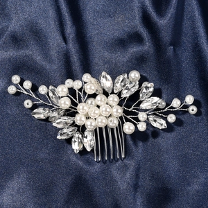 Detailed view of handmade bridal hair comb with pearls and rhinestones on blue silk