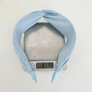 Detail shot showing a pleated light blue headband on a scale weighing 31.38 grams
