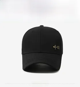 Detail of black cotton baseball cap showing side golden metal emblem with fine stitching