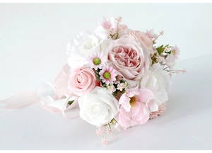 Close-up of artificial bridal bouquet with pink and white roses, peonies and silk ribbons