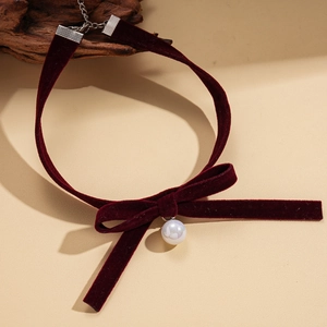 Detail of burgundy velvet choker with elegant bow and white pearl drop pendant
