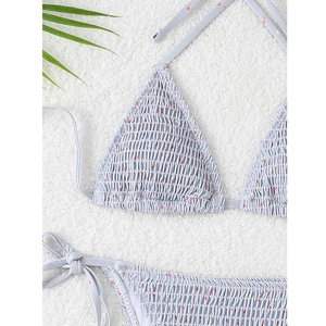 Detail of floral smocking fabric on light blue triangle bikini with side-tie bottoms