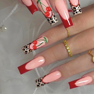 Coffin press-on nails with red French tips, leopard print, and 3D cherry accents on mesh