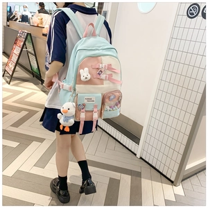 Detailed close-up of a pastel patchwork school backpack with cute plush charms and badges