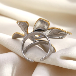 Gros plan d'une bague fleur bicolore plaquée or 18 carats sur velours beige