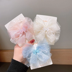 Handmade chiffon bow hair clips in pink, white, and blue with delicate bead accents