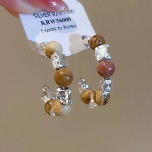 Détail de créoles en argent 925 avec perles d'oeil de tigre et perles naturelles