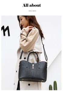 Detailed view of black crocodile pattern handbag with elegant gold metal lock and handle