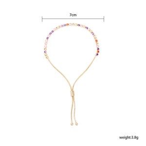 Dettaglio del bracciale regolabile color oro con cristalli di zirconia cubica colorati