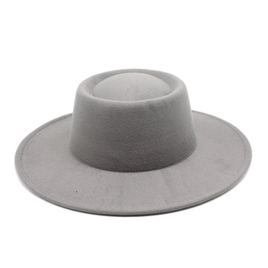 Macro detail of a grey wool fedora hat with a flat brim and circular indented crown