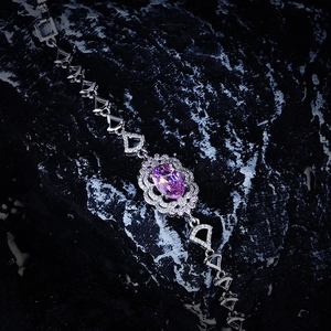 Macro detail of oval purple gemstone bracelet with silver geometric chain links