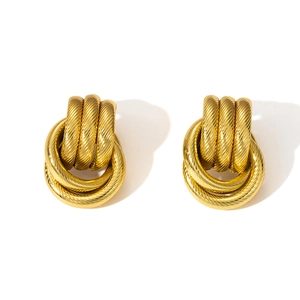 Macro view of triple layered gold-plated hoop earrings with elegant textured ribbing
