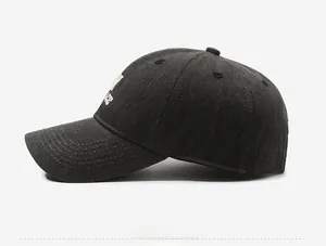 Detail of dark grey baseball cap showing 3D letter embroidery and premium stitching