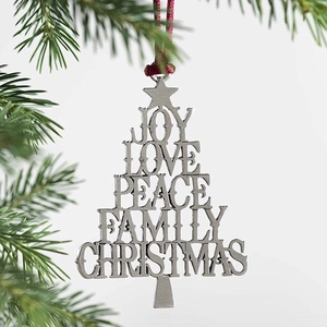 Silver metal Christmas tree ornament with engraved words hanging on a green pine branch