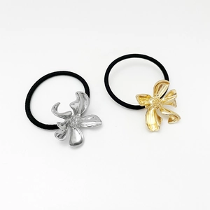 Close-up of gold and silver irregular leaf flower hair rings with elastic bands
