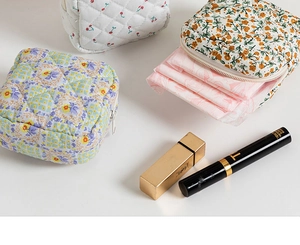 Detailed view of quilted cotton cosmetic bags in cherry, floral, and checkered patterns
