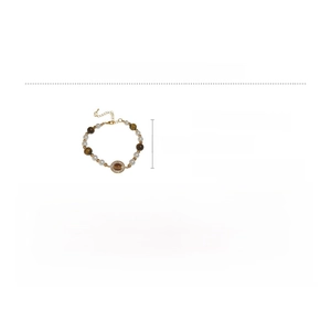 Détail du bracelet en perles avec pierres œil de tigre et breloque en strass
